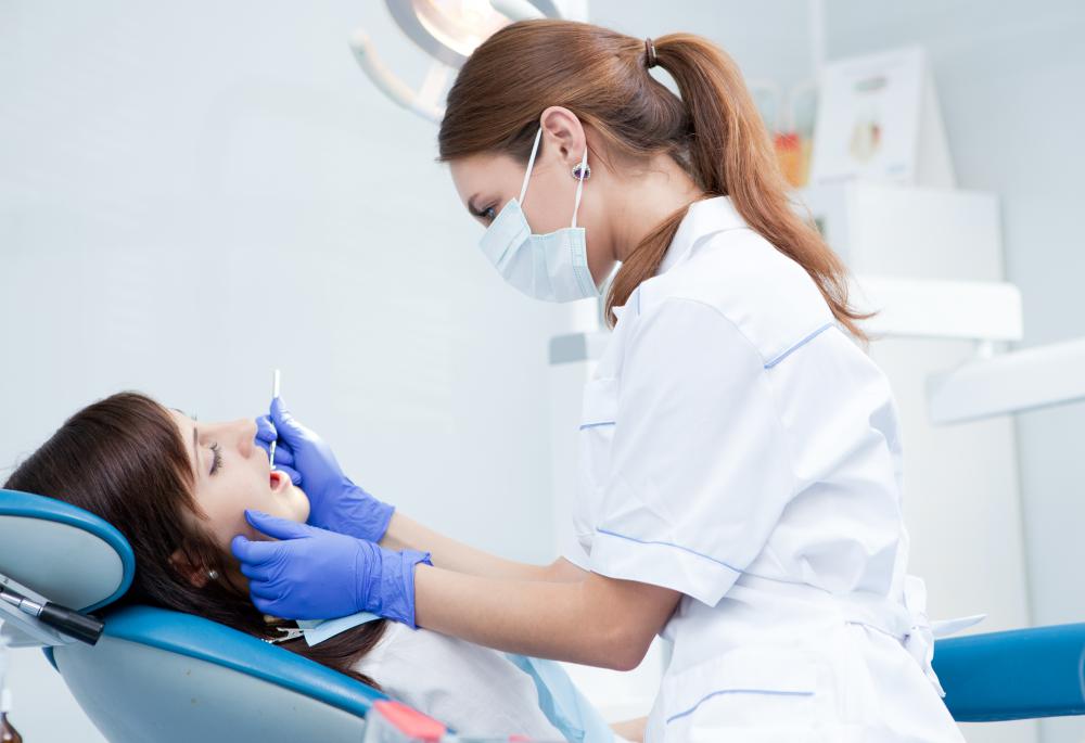 A dental hygienist cleaning a person's teeth.