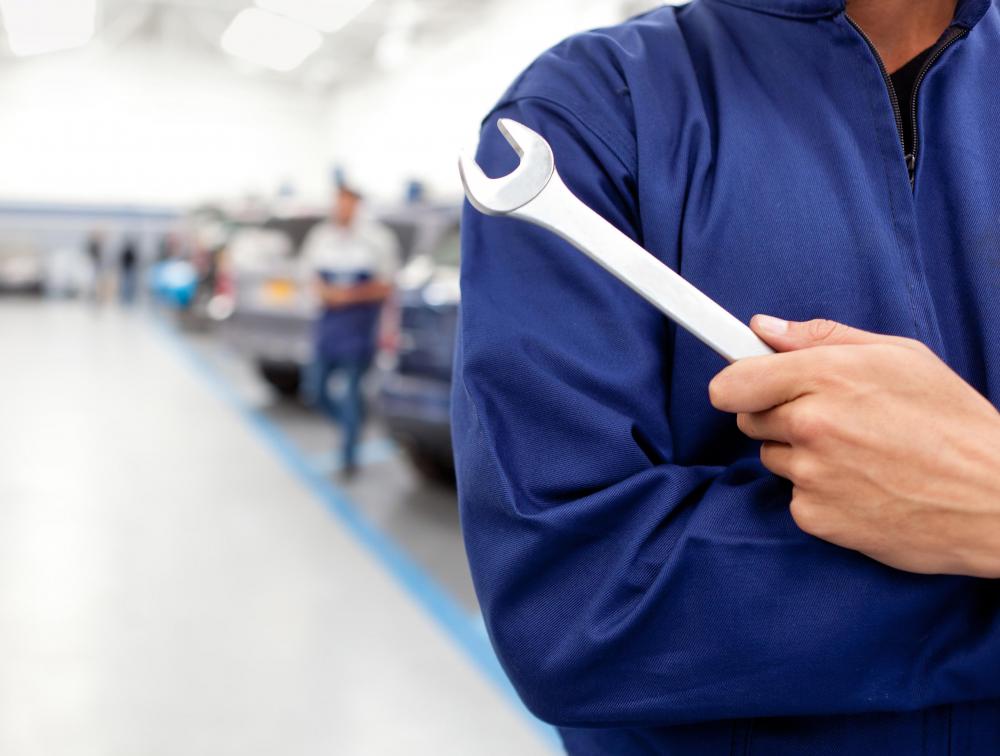 An auto body mechanic focuses on a vehicle's body.