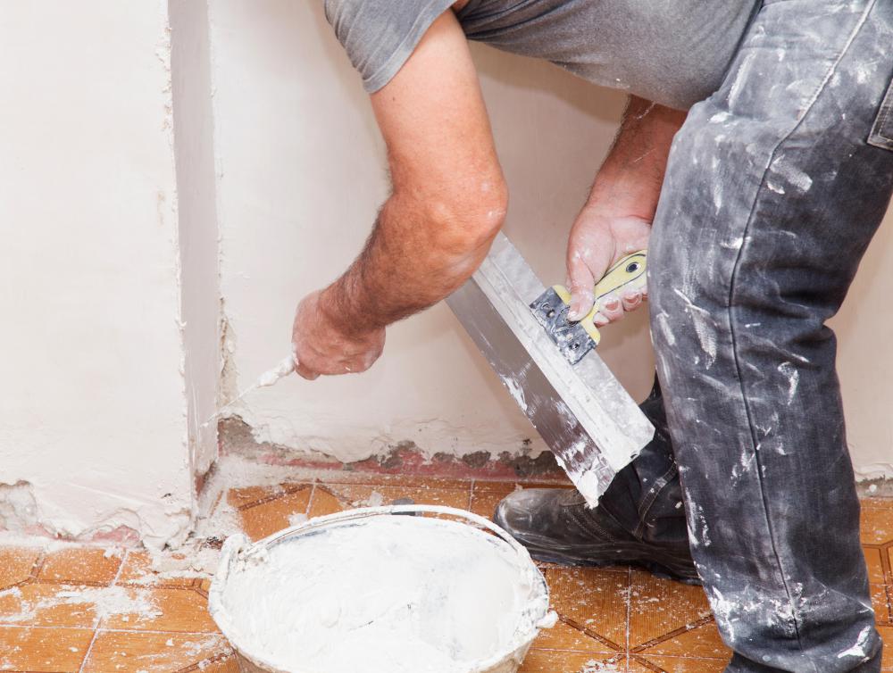 A plasterer may apply plaster on walls to manage repairs of an older building.