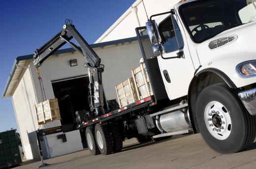 A loader crane is used to load materials on and off of a truck.