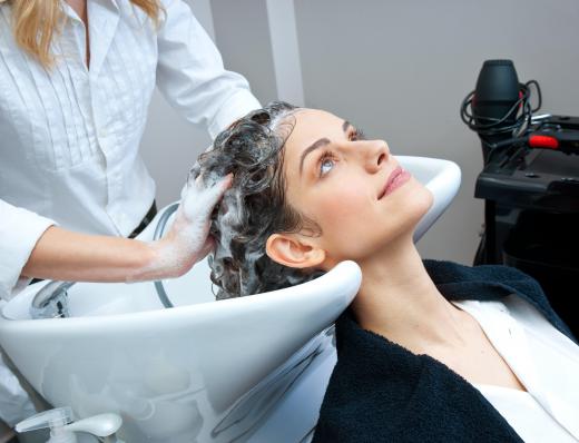 A salon apprentice may help out by washing the customer's hair.