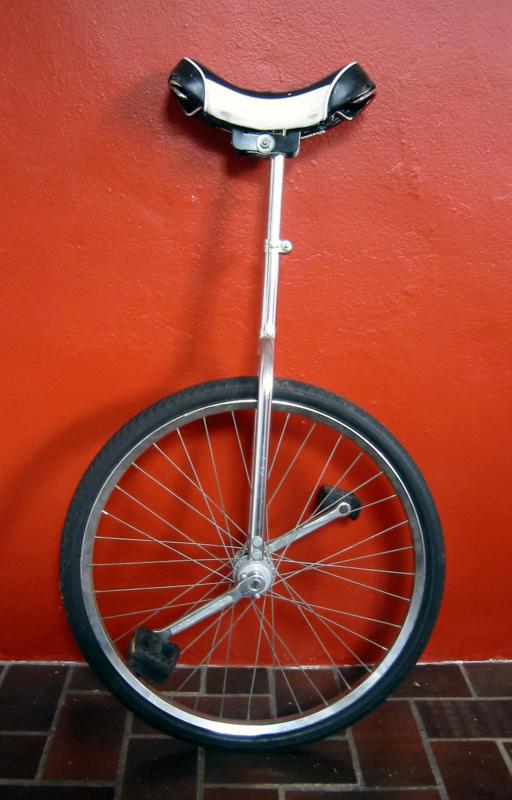 A clown often performs a routine on a unicycle.