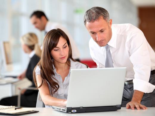 An administrative coordinator discussing a budget with a co-worker.