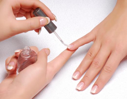 A nail technician polishing a woman's fingernails.