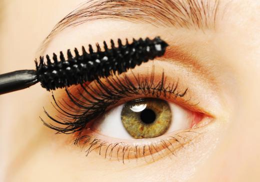 A beauty expert applying mascara to a client.