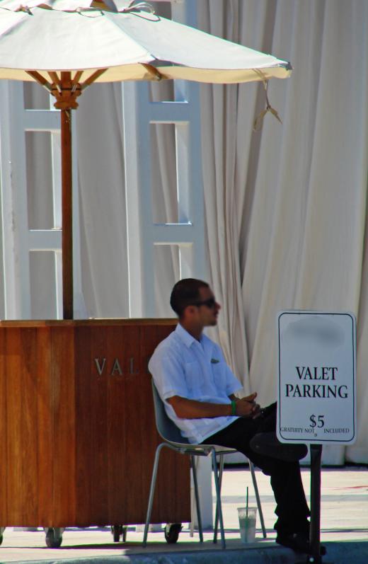 A parking lot attendant oversees the lot and ensures it operates in an organized fashion.