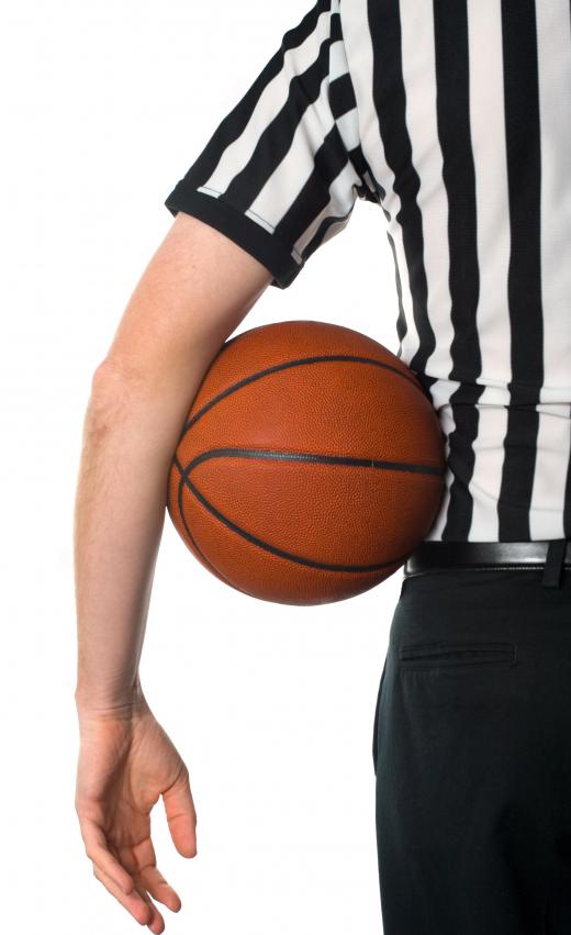 A basketball referee makes sure games are played by the rules.