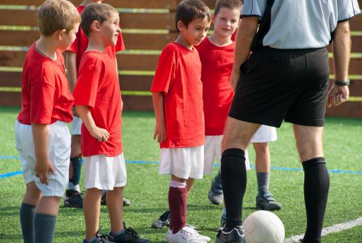 Coaches teach young soccer players the fundamentals of ball control.