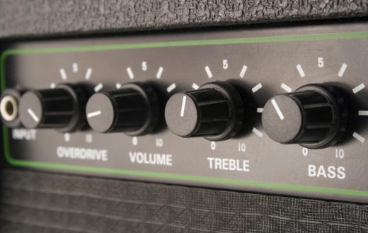 A guitar technician moves, sets up and maintains a guitar player's amplifier.