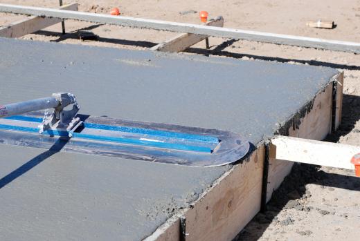 Some workers install concrete slabs for foundations.