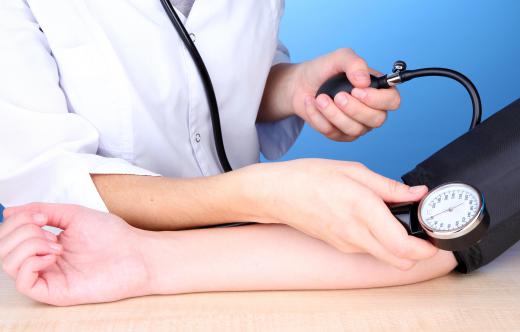 A telemetry nurse uses different types of technology to monitor a patient's blood pressure.