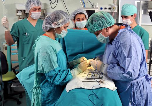 An anesthesia technician works alongside surgeons in an operating room.