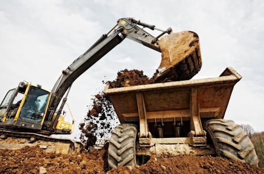 Dump truck trainees monitor the loading of dump trucks to ensure loads are evenly distributed.