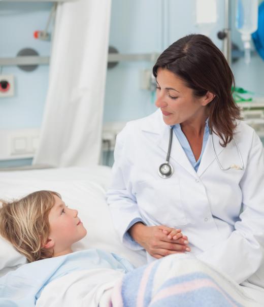 A pediatric oncologist speaking with a young patient.