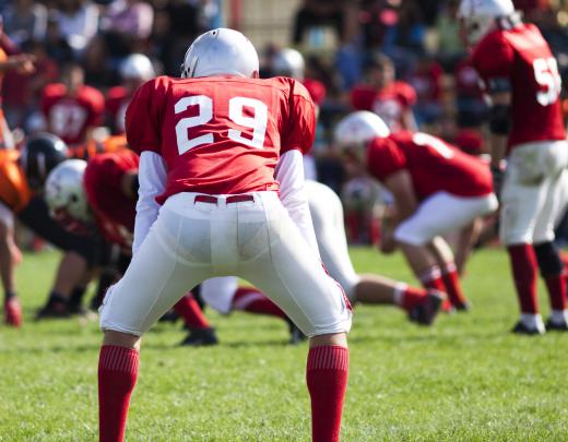 Football coaches teach players skills such as blocking and tackling.