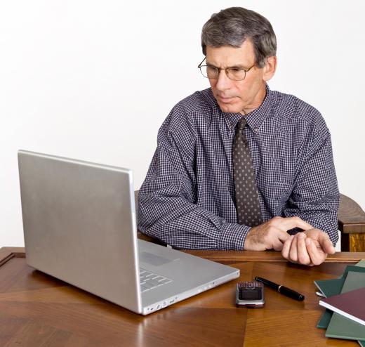 A man his pulse while reading information from an online medical advisor.