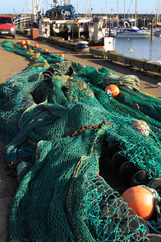 A boatman is responsible for attending to fishing nets aboard a fishing vessel.