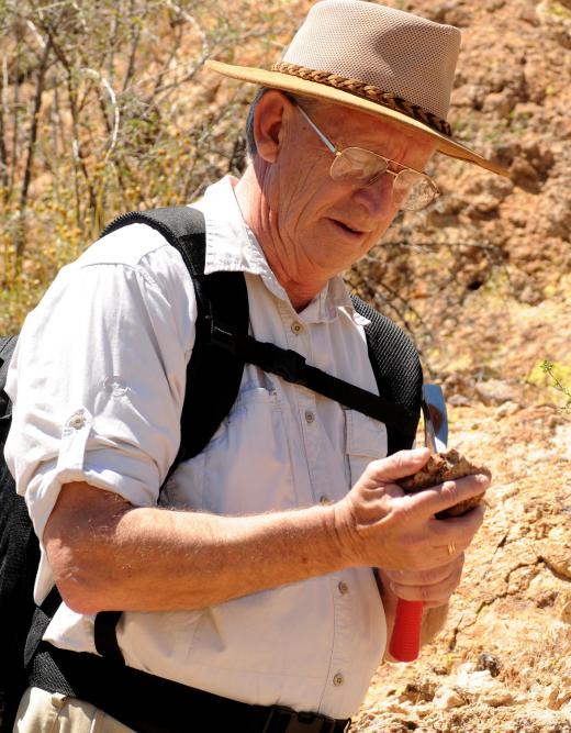 A mudlogging geologist inspects the rock and mud extracted from an oil well borehole.