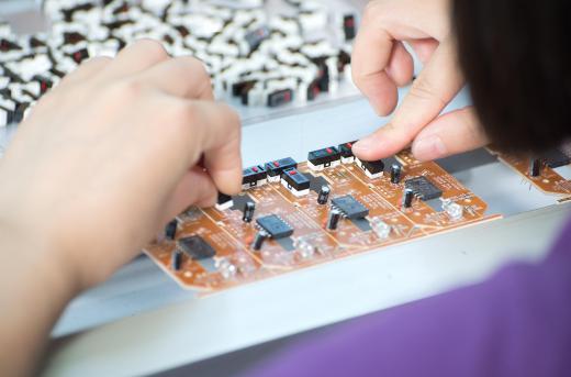 Inspectors visually examine the circuit board's exterior for any defects or loose components.