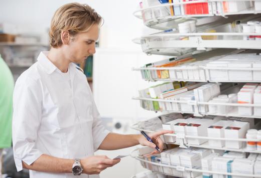 A pharmacy assistant properly sorts and stores medication.