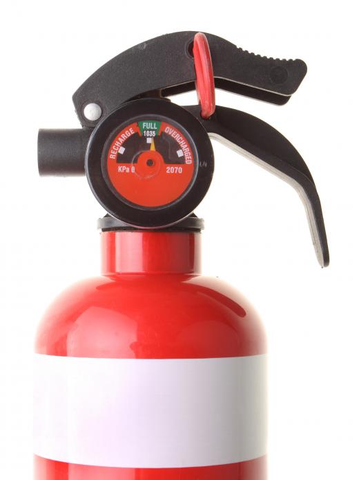 Fire extinguishers are checked by a fire marshal during an inspection.