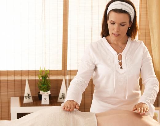 A reiki teacher instructs students on how to perform reiki, a form of spiritual healing involving the transference of energy from healer to patient.