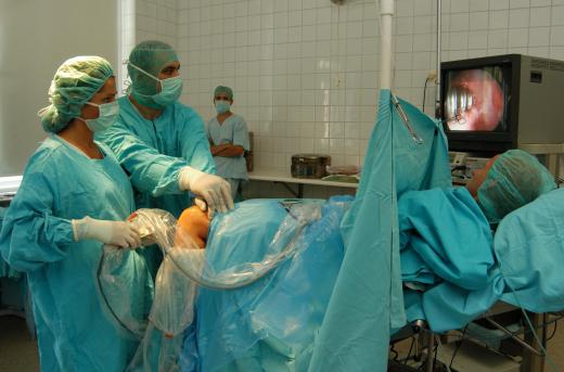 A scrub nurse works in a hospital operating room.