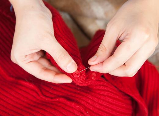 Seamstress sewing in a button.