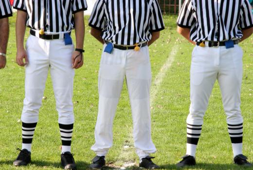 Multiple officials work as part of a crew during a football game.