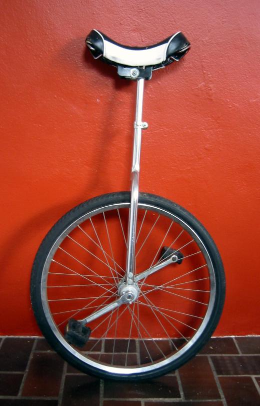 A clown often performs a routine on a unicycle.